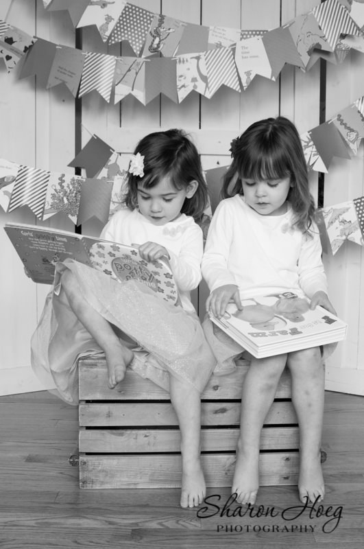black and white of two sisters sitting on a crate reading books, Northville Family Photography