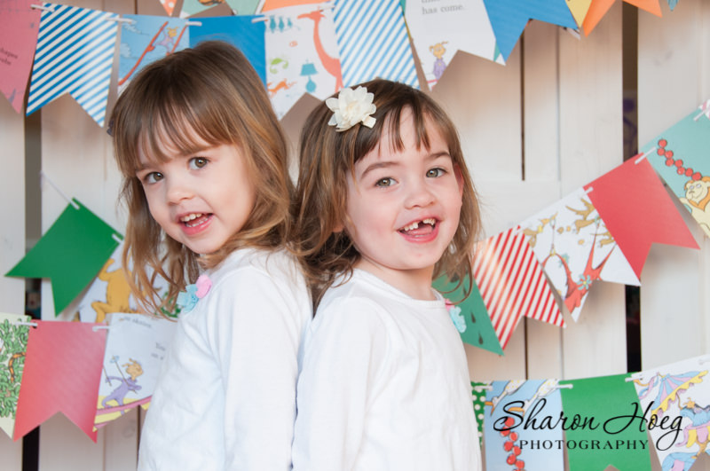 Twin girls smiling at the camera back to back, Northville Child Photographer