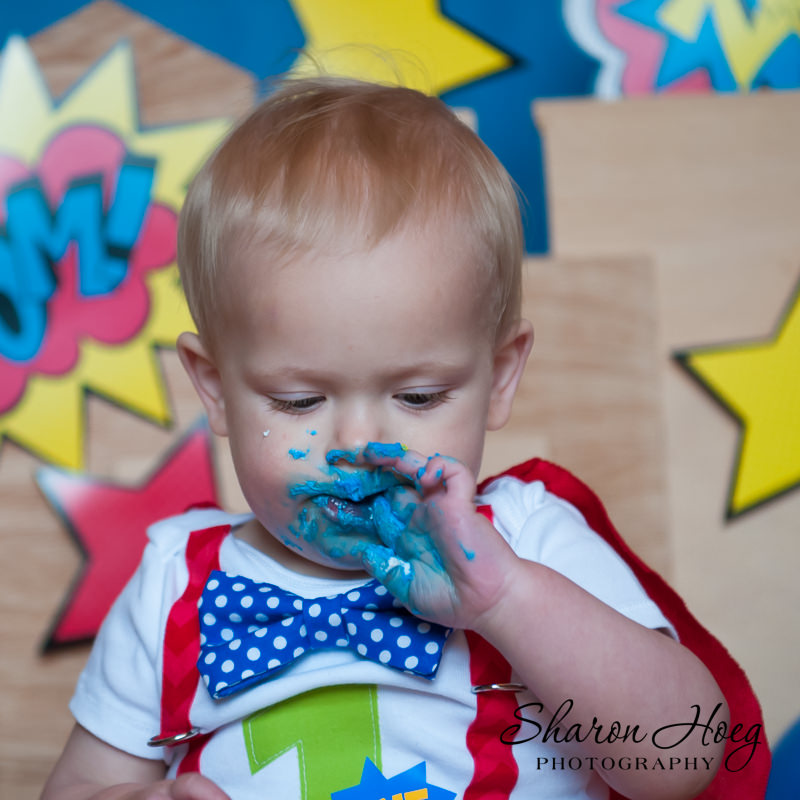 one-year-old boy eating blue frosting, Livonia Child Photograper