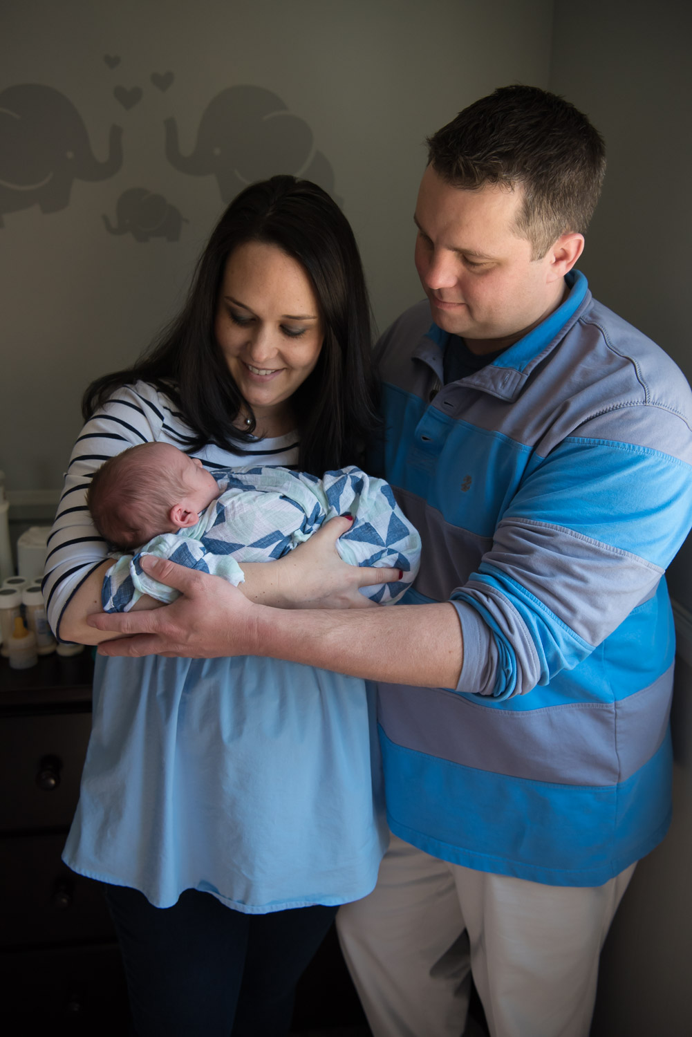 family holding baby in elephant nursery, newborn lifestyle photography