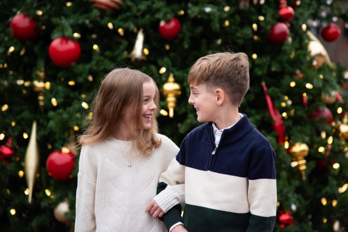happy siblings with christmas tree downtown northville holiday photos