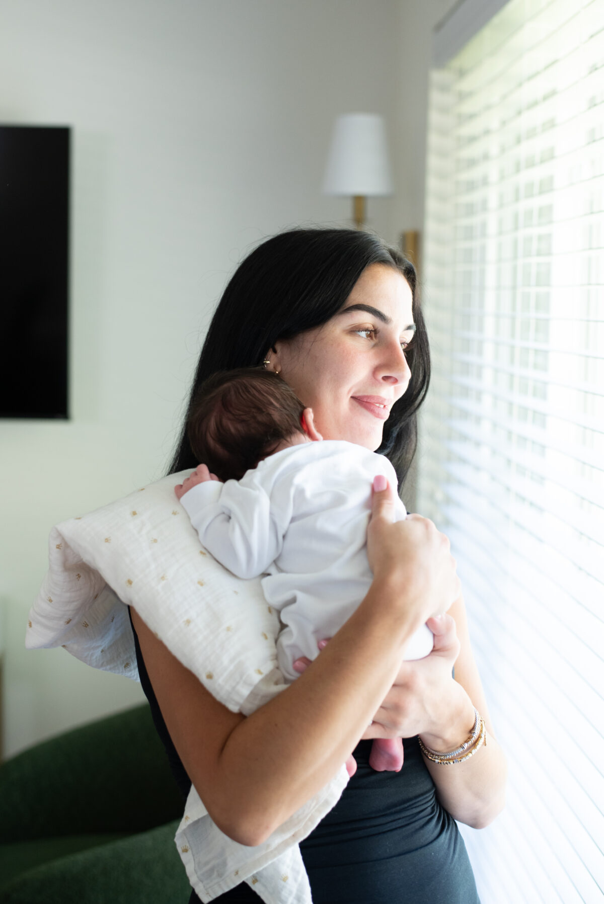 Mother snuggling new baby in Royal Oak Michigan